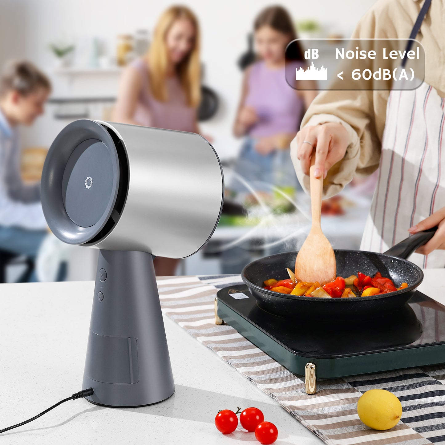 Portable range hood with a noise level indicator, placed on a kitchen counter next to a frying pan with sautéing vegetables, while a person stirs with a wooden spoon.