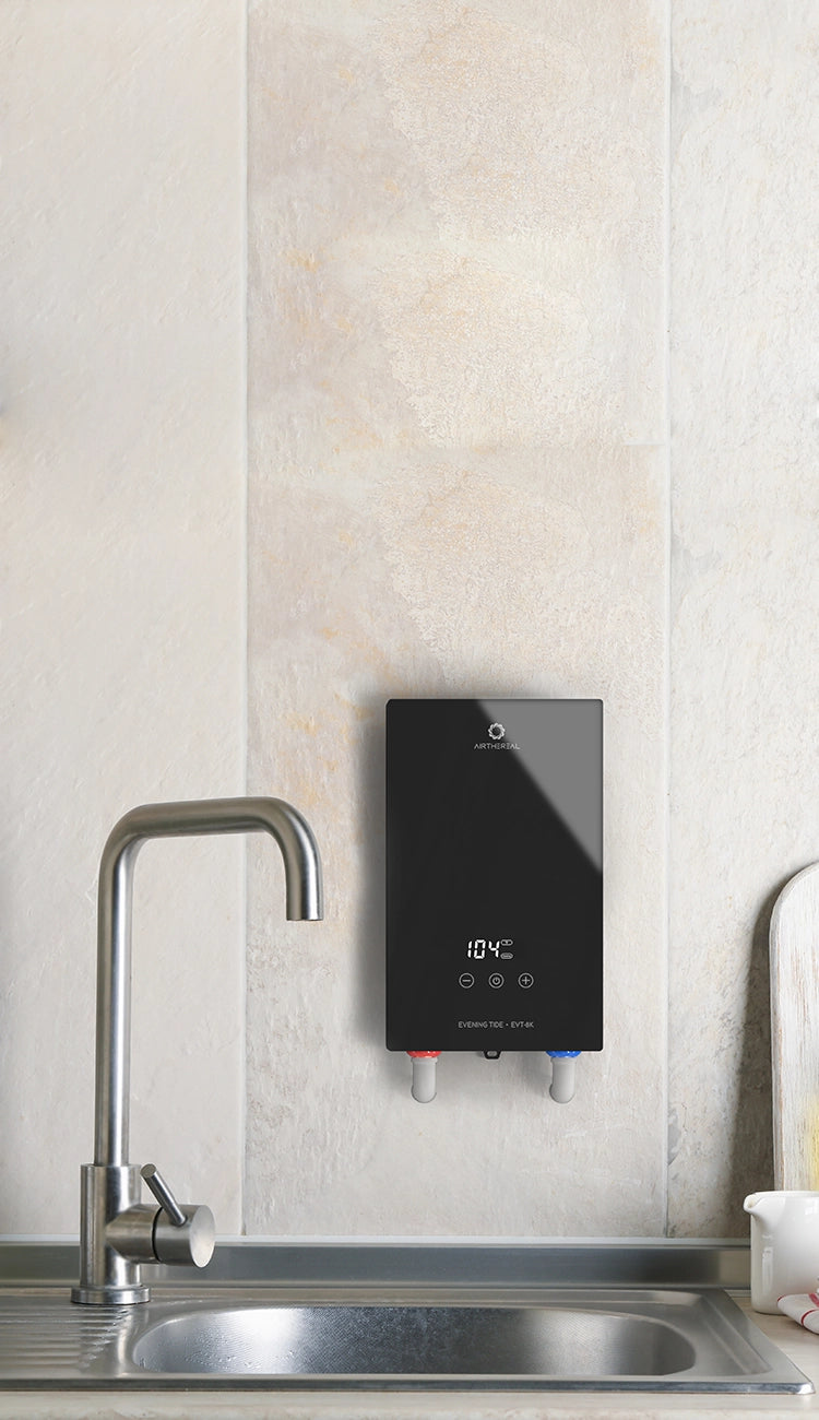 Black on-demand water heater mounted on a wall above a modern sink with greenery nearby.
