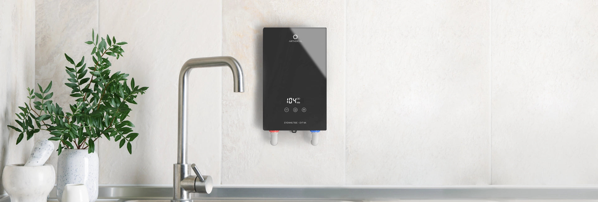 Black on-demand water heater mounted on a wall above a modern sink with greenery nearby.