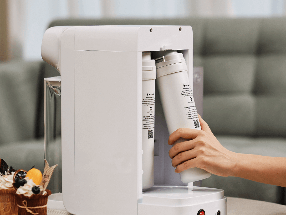 User replacing filters in a countertop water filtration system.