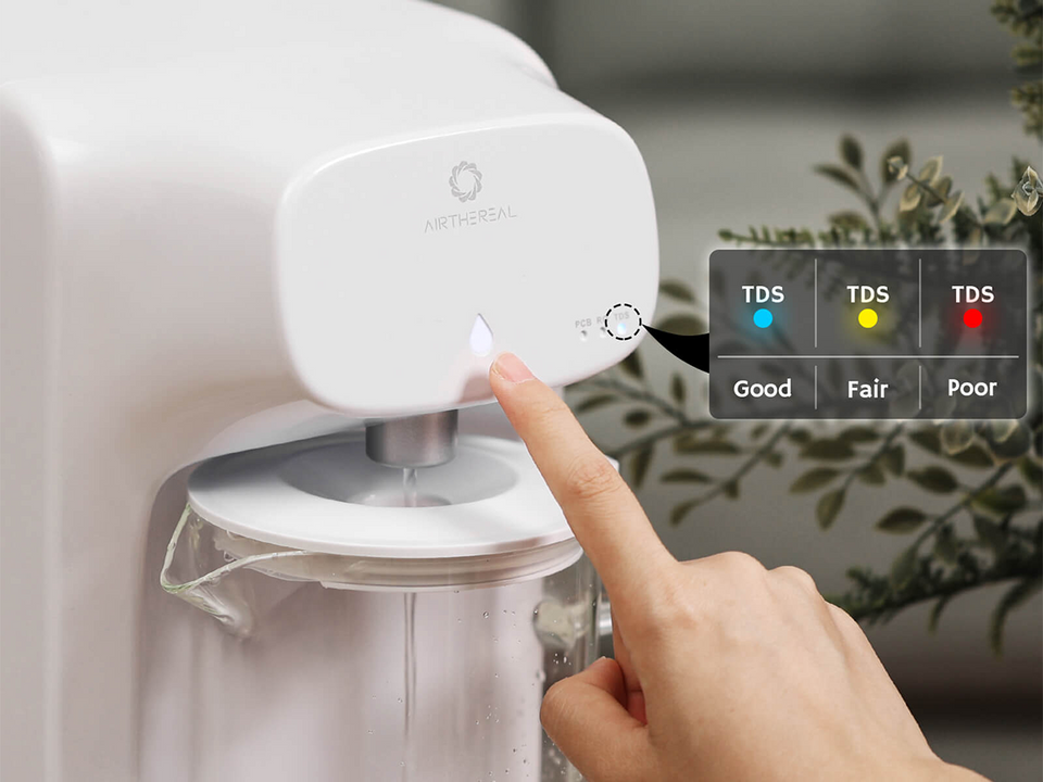 User interacting with a water filtration system, showing TDS indicator lights for water quality.